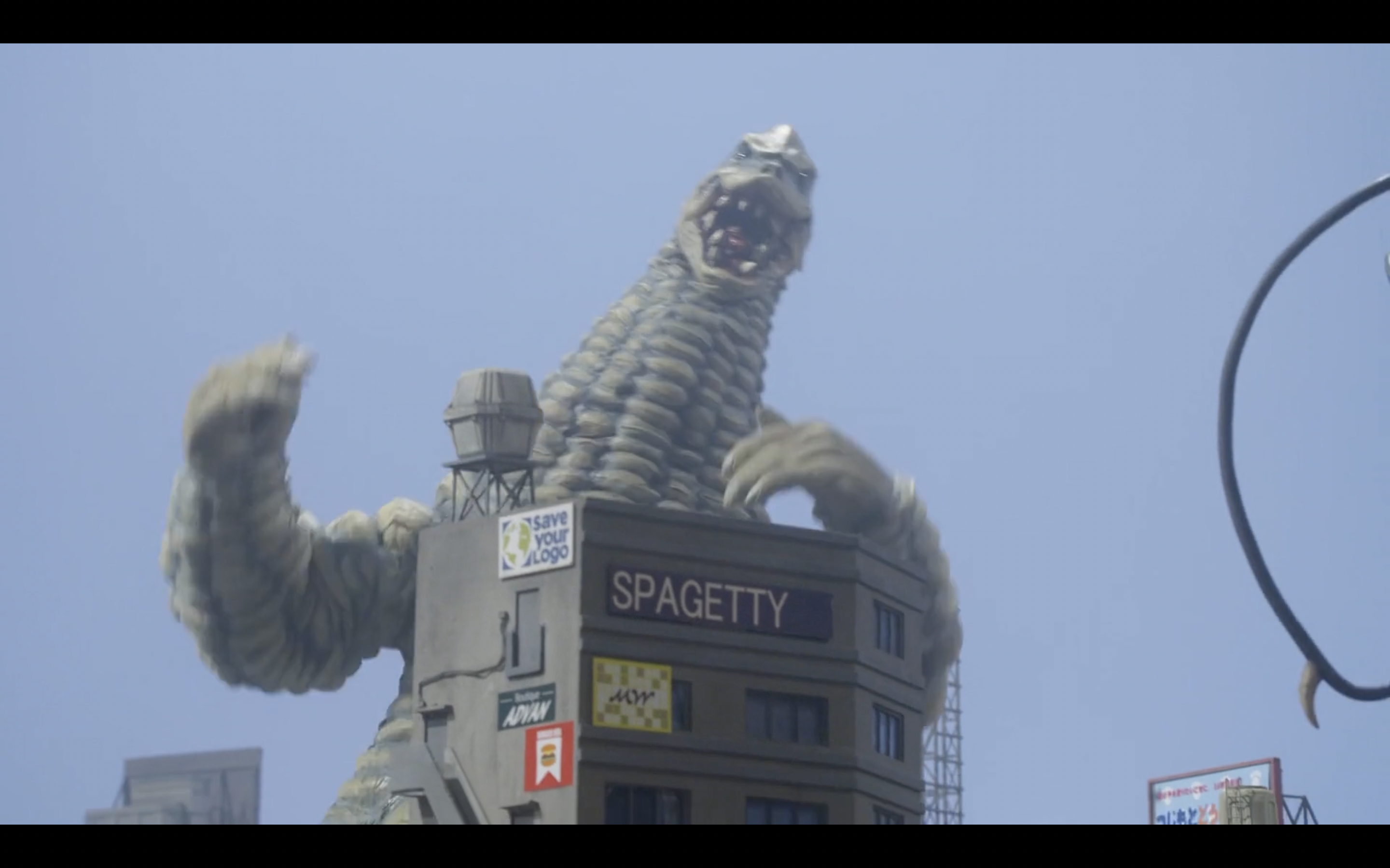 the Ultraman monster Red King standing in front of a sign that says 'Spagetty'